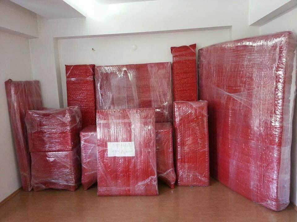 Kırmızı koruyucu ambalajla güvenli taşımaya hazırlanan mobilyalar